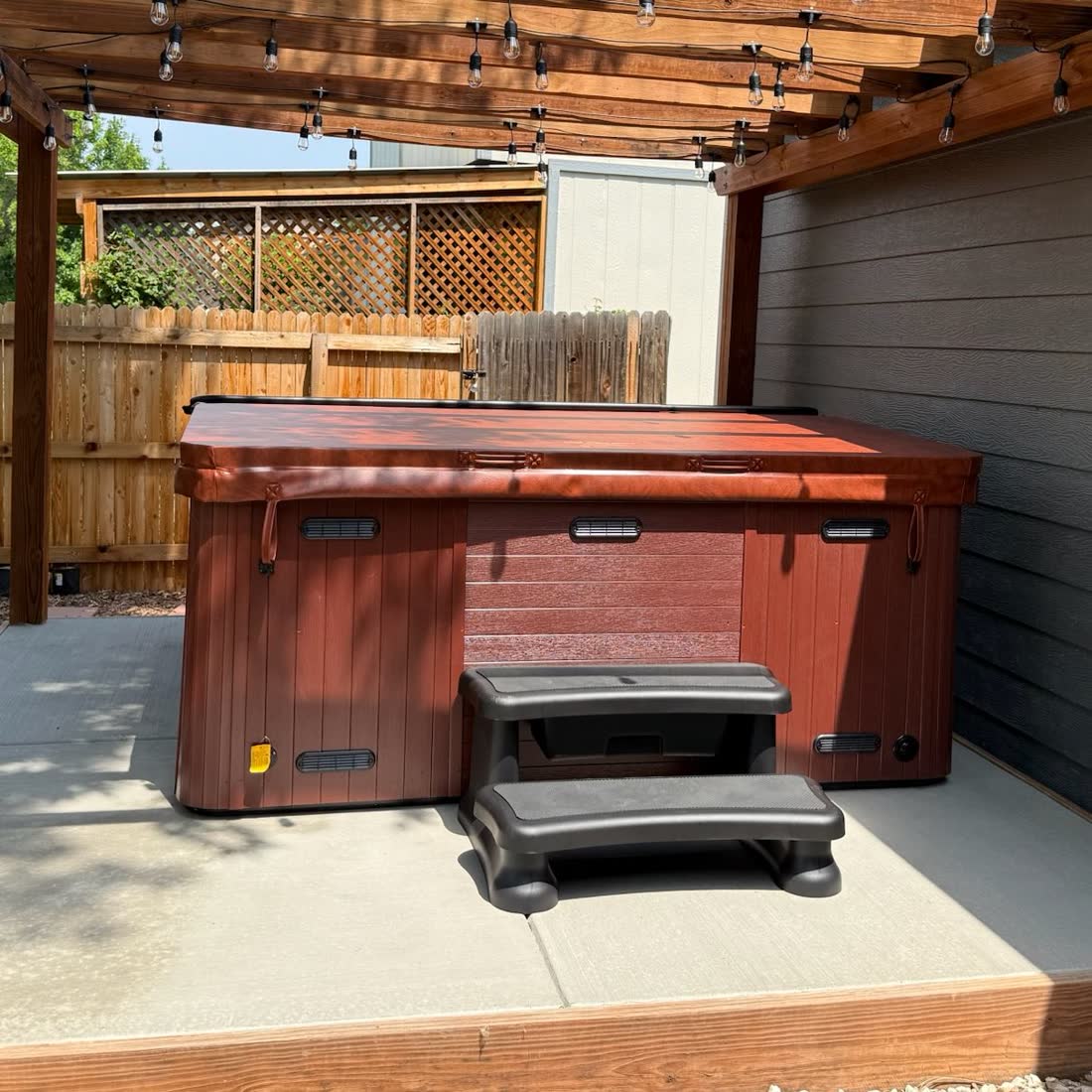 Concrete hot tub pad under a pergola